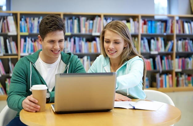 concetto di persone, istruzione, tecnologia e scuola - studenti felici con rete di computer portatili in biblioteca