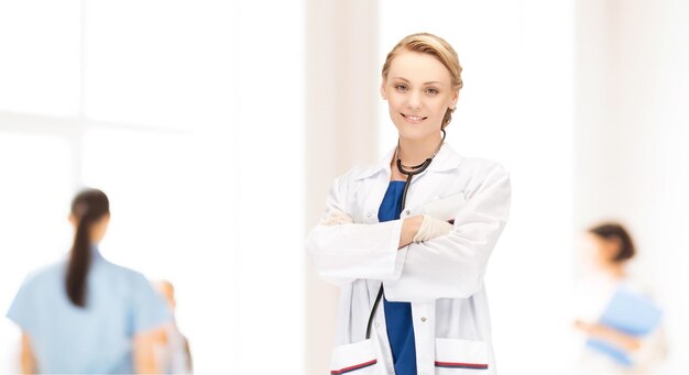 concetto di persone, medicina e professione - sorridente giovane dottoressa su sfondo clinica