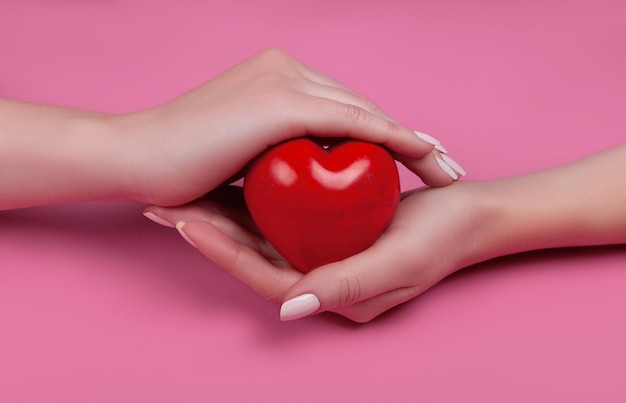 Concetto di persone, relazioni e amore - primo piano delle mani a coppa della donna che mostrano il cuore rosso