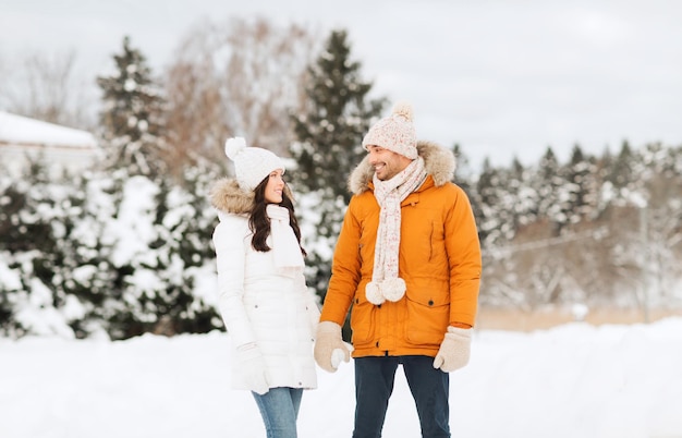 concetto di persone, stagione, amore e tempo libero - coppia felice che cammina su sfondo invernale