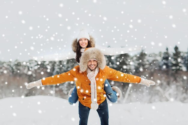 concetto di persone, stagione, amore e tempo libero - coppia felice che si diverte su sfondo invernale