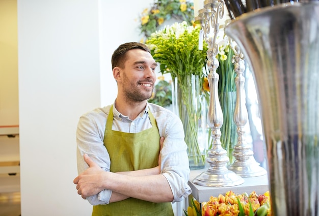 concetto di persone, vendita, vendita al dettaglio, affari e floristica - felice fiorista sorridente uomo in grembiule in piedi al negozio di fiori