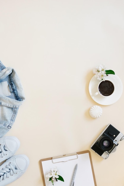 Concetto di pianificazione delle vacanze ancora in vita Vestiti una tazza di caffè, una fotocamera e un blocco note con una penna