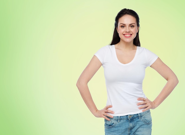 concetto di pubblicità, abbigliamento e persone - giovane donna o adolescente sorridente felice in maglietta bianca su sfondo verde naturale