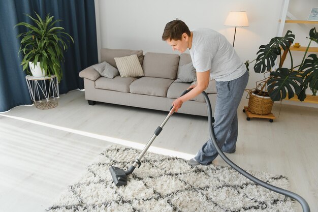 Concetto di pulizia donna pulizia tappeto con aspirapolvere
