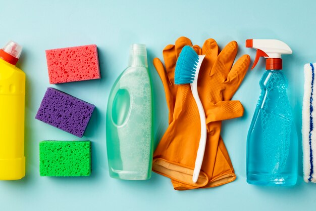 Concetto di pulizia. Set di prodotti per la pulizia su sfondo blu, vista dall'alto