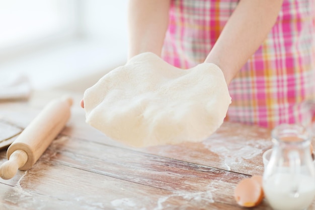 concetto di raffreddamento e casa - primo piano delle mani femminili che tengono la pasta del pane