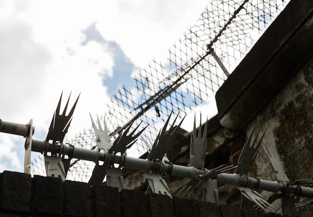 concetto di reclusione - chiusura del recinto con filo spinato e rete in prigione
