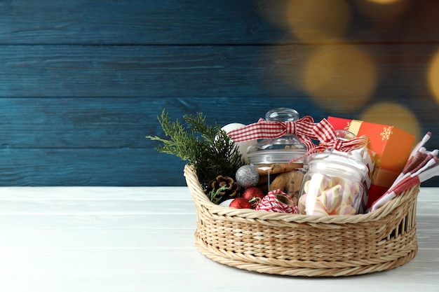 Concetto di regalo con cesto di Natale su tavola di legno bianco