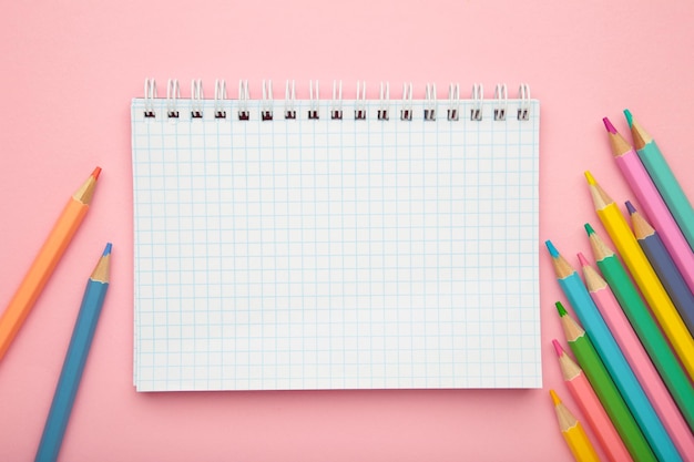 Concetto di rifornimenti scolastici Quaderno aperto con matita colorata