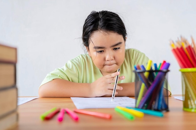 Concetto di ritorno a scuola Una ragazza asiatica sta facendo la pratica dei compiti facendo esercizi di miglioramento delle abilità