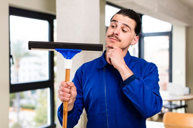 Concetto di rondella di finestre del giovane uomo bello all'interno domestico