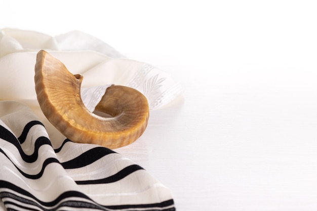 Concetto di Rosh Hashanah (festa ebraica). Tallit, shofar (corno), mela e melograno isolati su bianco. simbolo di vacanza tradizionale.