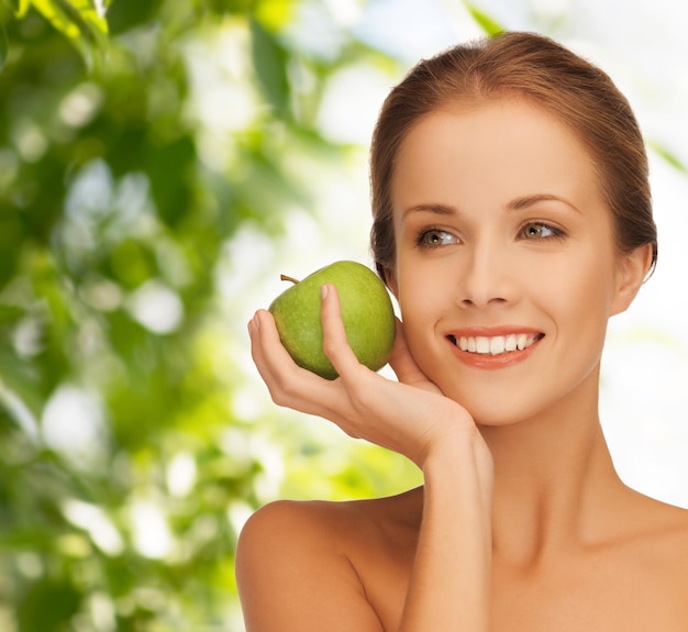 concetto di salute, bellezza, cibo vegetariano e persone - giovane donna sorridente con mela su sfondo verde