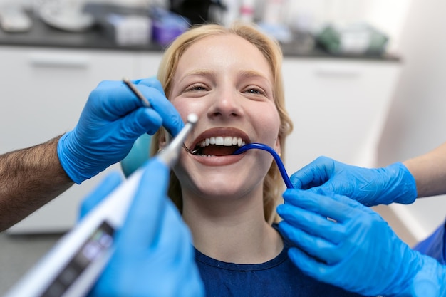 Concetto di salute dei denti Foto ritagliata della bocca sorridente della donna in trattamento presso il panorama della clinica dentale