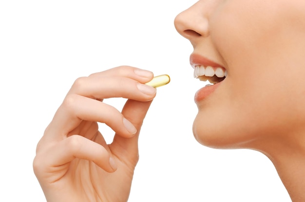 concetto di salute e bellezza - bella donna con vitamine omega 3