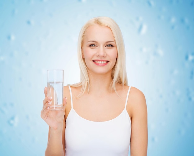 concetto di salute e bellezza - giovane donna sorridente con un bicchiere d'acqua