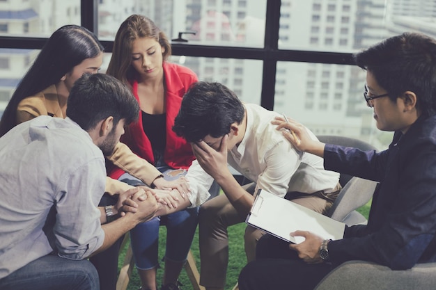 Concetto di salute mentale, gruppo di giovani problematici che parlano con un consulente di orientamento. Gruppo di seduta di terapia e conversazione. Diverse persone che parlano, aiutano e danno supporto.