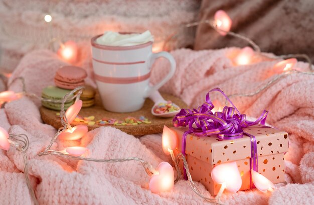 Concetto di San Valentino con confezione regalo fatta a mano e molti piccoli cuoricini Luci a cuore rosa