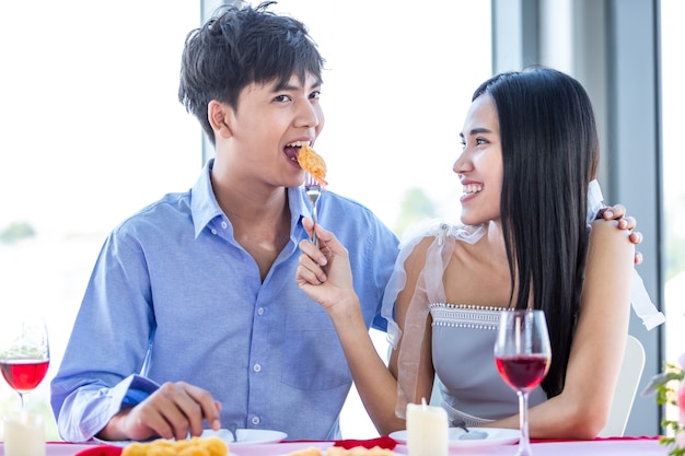 Concetto di San Valentino, Felice coppia asiatica giovane dolce che ha romantico il pranzo con un mazzo di rose sullo sfondo del ristorante, Coppia storia d'amore