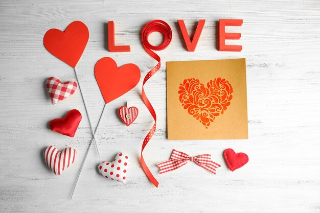 Concetto di San Valentino Iscrizione amore con cuori e carta su sfondo tavolo in legno