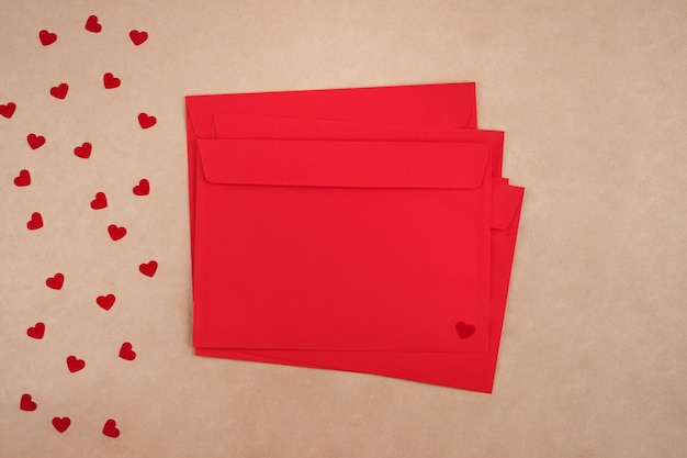 Concetto di San Valentino. Pila di buste rosse e cuori di carta. Lay piatto.