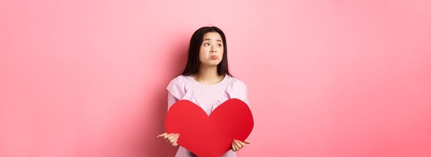 Concetto di San Valentino ragazza asiatica adolescente sola che sogna l'amore sentendosi triste e sola per gli amanti da