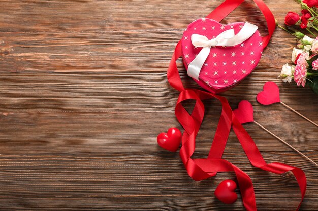 Concetto di San Valentino Rose fresche e confezione regalo su tavola di legno