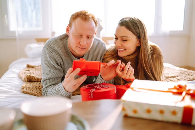 Concetto di San Valentino Scambio di doni Giovane coppia a casa che celebra il giorno di San Valentino