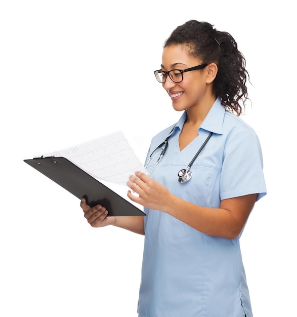 concetto di sanità e medicina - medico o infermiere afroamericano femminile sorridente in occhiali con stetoscopio e appunti