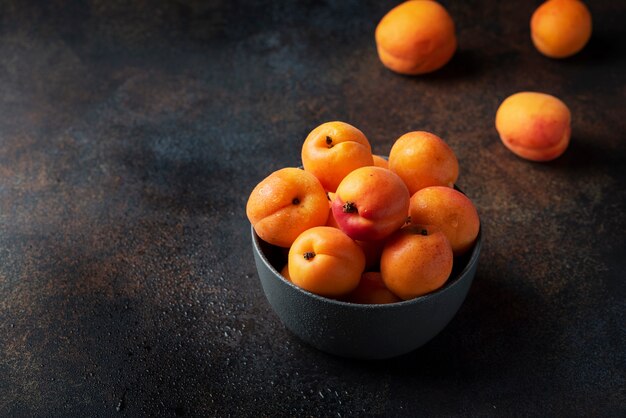 Concetto di sano cibo vegano con albicocche dolci in uno sfondo scuro,