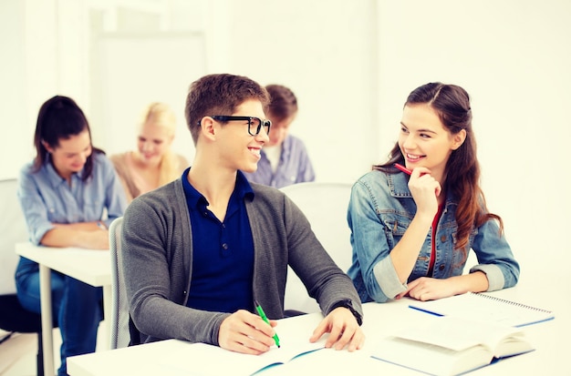 concetto di scuola e istruzione - gruppo di studenti sorridenti con quaderni a scuola