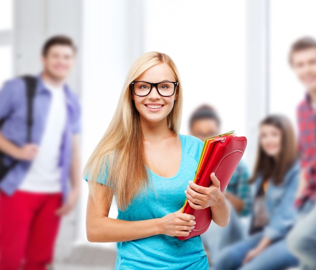 concetto di scuola e istruzione - studente sorridente con cartelle