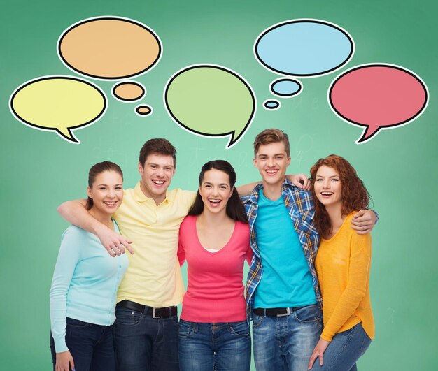 concetto di scuola, istruzione, comunicazione e persone - gruppo di adolescenti sorridenti su sfondo verde con bolle di testo