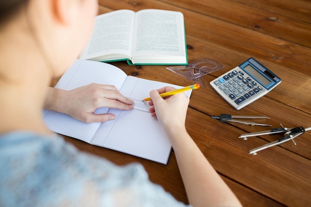 concetto di scuola, istruzione, persone e apprendimento - primo piano delle mani di uno studente o di una donna con righello e linea di disegno a matita nel taccuino