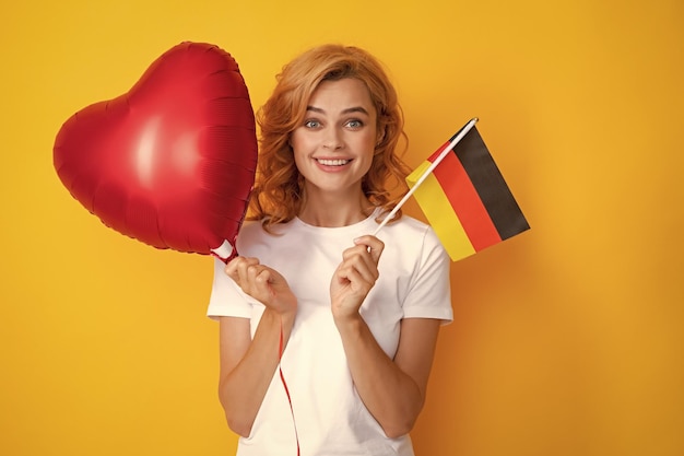 Concetto di scuola o università in Germania Donna felice che tiene la bandiera dell'immigrazione tedesca e viaggia in Europa Bandiera della Germania Bandiera tedesca della Germania