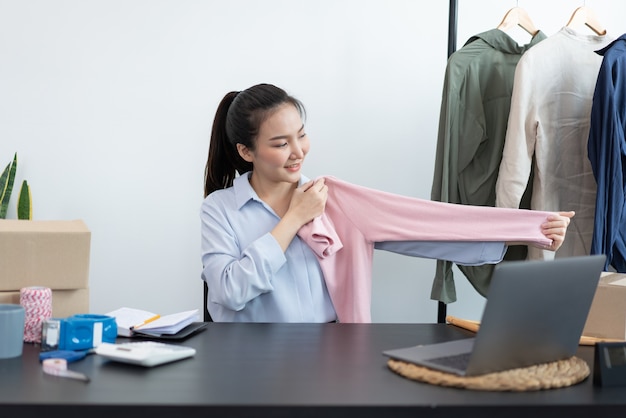 Concetto di shopping dal vivo un commerciante femminile che mostra un rapporto di dimensioni del prodotto per i clienti online.