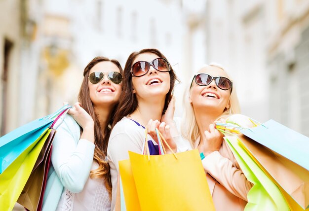 concetto di shopping e turismo - belle ragazze con borse della spesa in ctiy