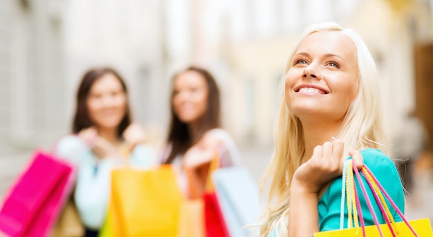 concetto di shopping e turismo - belle ragazze con borse della spesa in ctiy