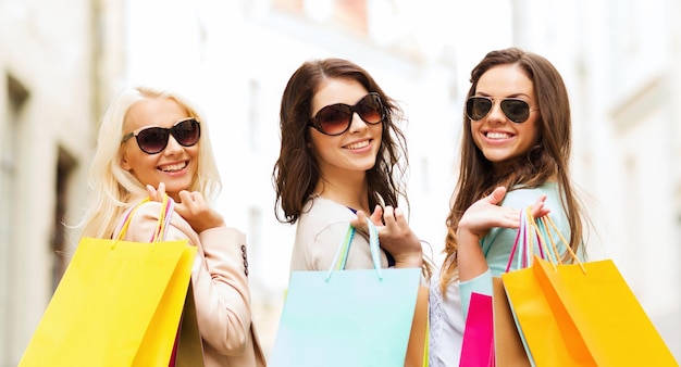 concetto di shopping e turismo - belle ragazze con borse della spesa in ctiy