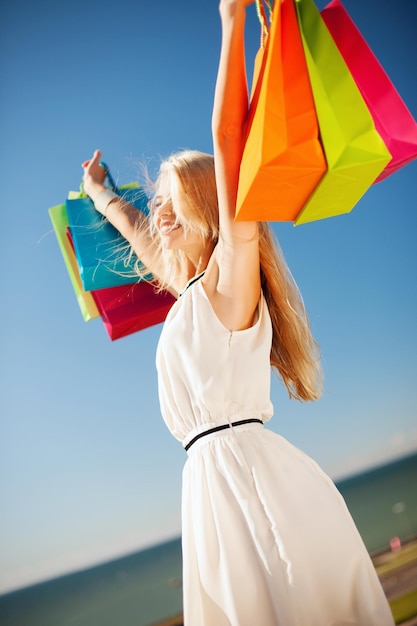 concetto di shopping e turismo - donna con borse della spesa