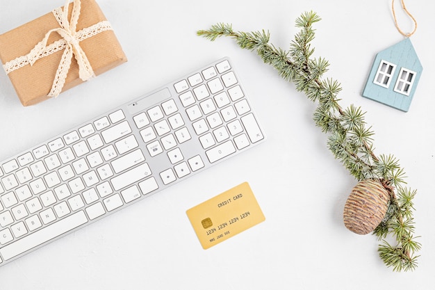 Concetto di shopping natalizio online con scatole regalo, tastiera e carta di credito dorata. Vista dall'alto, piatto