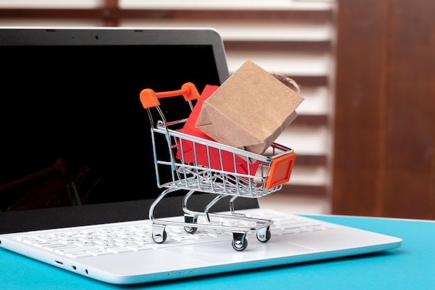 Concetto di shopping online. Carrello della spesa, laptop sulla scrivania