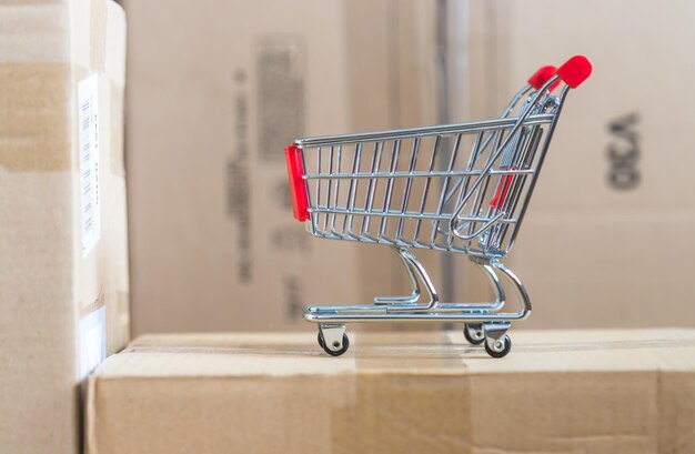 Concetto di shopping online Piccolo carrello sulle scatole di consegna