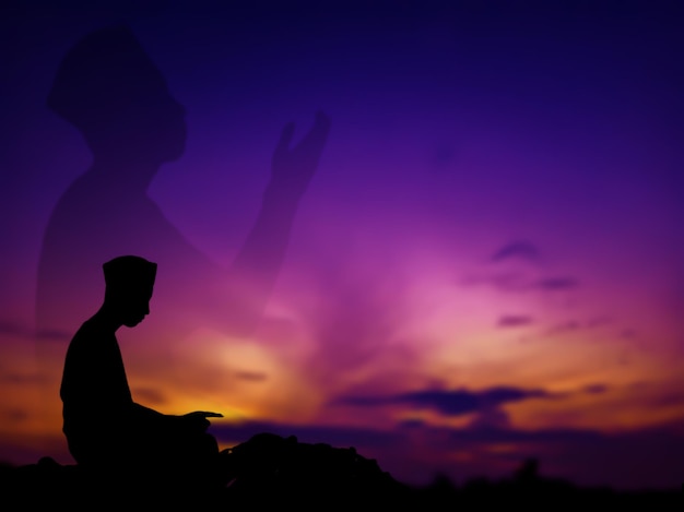 Concetto di silhouette dell'uomo musulmano che prega allah sulla collina con un bellissimo panorama naturale al tramonto concentrarsi sulle persone