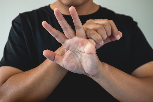 Concetto di sindrome dell'ufficio Little Finger viene massaggiato e allungato dopo il lavoro Primo piano isolato su sfondo blu Vista frontale