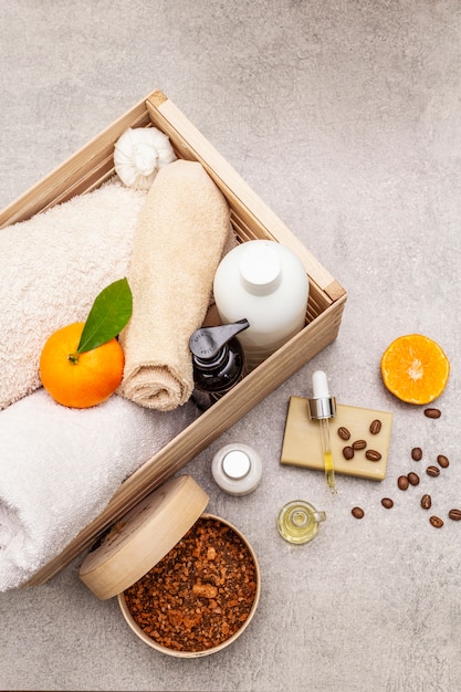 Concetto di spa di caffè e mandarino. Asciugamani, olio, scrub, sapone, lozione. Ingrediente naturale, scatola di legno.