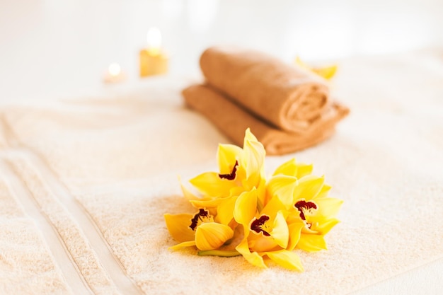 concetto di spa, salute e bellezza - primo piano di asciugamani, fiori e candele