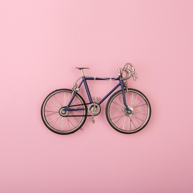 Concetto di sport biciclette giocattolo su sfondo rosa