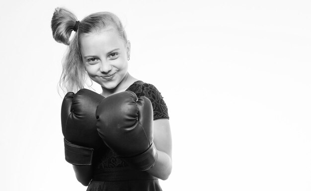 Concetto di sport e salute Boxe sportivo per donna Bambina con guanti blu in posa su sfondo bianco Educazione sportiva Sii forte Boxe bambino forte Educazione per la leadership e il vincitore